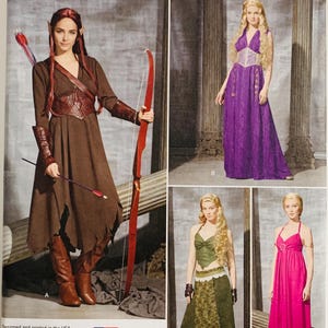 May include: Simplicity sewing pattern 1010 H5 for costumes in sizes 6-14. The envelope displays four variations: a brown dress with a bow and arrow, a purple floor-length gown, a green two-piece outfit, and a pink halter-style maxi dress.