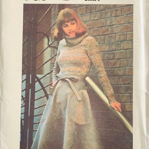 May include: A vintage sewing pattern titled "SEW & GO" featuring a woman wearing a gray turtleneck sweater and a gray patch-pocketed flare skirt. The pattern's title is displayed with a black graphic.