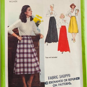 May include: A white ceramic mug with a black handle and the text "But First, Coffee" in a bold, black font. The mug is set against a blurred background, suggesting a cozy setting.