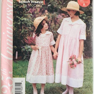 May include: Image of a vintage sewing pattern cover featuring two young girls in matching dresses and straw hats. The pattern is labeled "Easy stitch 'n save by McCall's" and includes the size range "CHILD (2-3-4-5-6)". The cover has a pink and white color scheme.