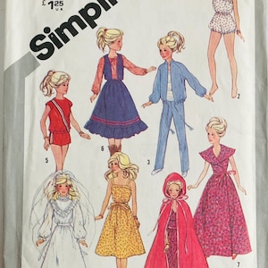 May include: Vintage Simplicity sewing pattern featuring illustrations of various doll outfits. The pattern includes designs for a wedding dress, dresses, a jumpsuit, and a cape. The pattern is marked "One Size" and includes the price.