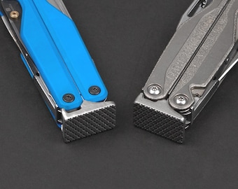 May include: Two multi-tools positioned side by side. The left tool features a bright blue handle with black screws and a textured metal base. The right tool is finished in a metallic grey with silver screws and a matching textured metal base.