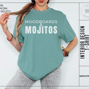May include: A teal blue t-shirt with the text "Moodboards & Mojitos" in white. The shirt is being modelled by a person.