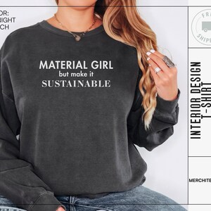 Puede incluir: Una sudadera gris oscuro con el texto "MATERIAL GIRL but make it SUSTAINABLE" impreso en blanco.