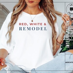 May include: White t-shirt with the text "RED, WHITE & REMODEL" in red and blue. The shirt also features the text "INTERIOR DESIGN T-SHIRT" and "MERCHITECTURE".