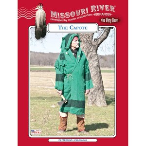 May include: A person wearing a green capote, a hooded cloak, with black stripes and fringe, holding an axe. The image is set against a backdrop of a field and a tree, with text that reads "MISSOURI RIVER BRAND" and "The Capote".