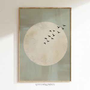 May include: A framed art print featuring a large, textured, off-white circle with a flock of black birds flying across it. The background is a muted green-gray. The text "LOTUS WALL PRINTS" is at the bottom.