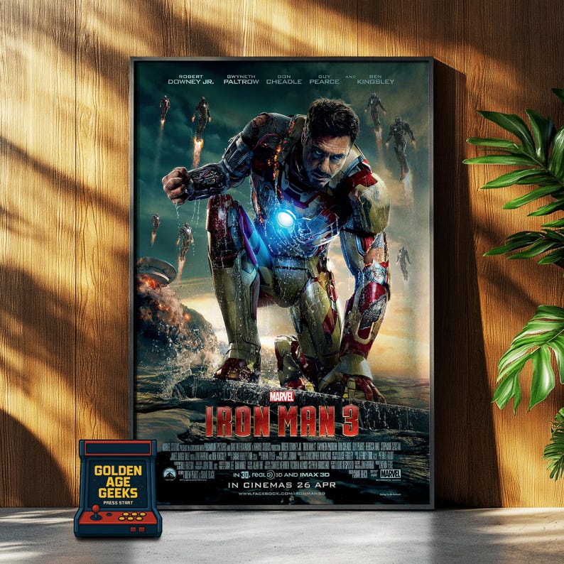 May include: A movie poster for Iron Man 3, featuring Robert Downey Jr. as Iron Man in a red and gold suit, standing in a watery environment. The poster includes the title "Iron Man 3" and the release date "In Cinemas 26 Apr".