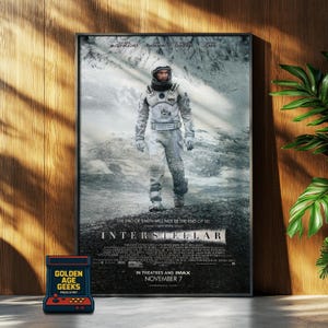 Puede incluir: Un póster enmarcado de la película "Interstellar" con un astronauta en un paisaje nevado. El póster tiene el título de la película y los nombres del elenco en la parte superior. Un pequeño juego de arcade está en primer plano.