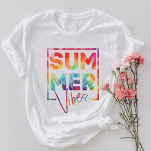 May include: White t-shirt with a rainbow tie-dye design that says "Summer Vibes" in a black box.