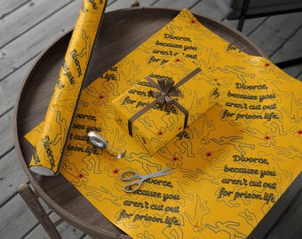 May include: Yellow wrapping paper and a wrapped gift with a brown ribbon. The paper has a repeating pattern of body outlines and the text "Divorce, because you aren't cut out for prison life."