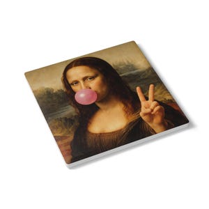 Pode incluir: Base de copo quadrada com uma paródia da Mona Lisa com uma bolha de goma de mascar rosa e um gesto de mão de sinal de paz. A obra de arte é uma versão humorística da pintura clássica, ambientada em um fundo de paisagem.