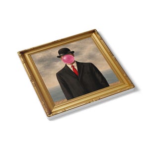 May include: Framed print depicting a man in a black suit, bowler hat, and red tie, with a pink bubble gum bubble covering his face. The artwork is set against a cloudy sky and ocean backdrop, within a gold ornate frame.