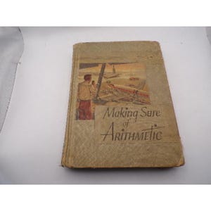 Puede incluir: Libro antiguo titulado "Making Sure of Arithmetic". La portada presenta una ilustración de una persona mirando un avión en una pista. El libro tiene una cubierta desgastada y texturizada con una combinación de colores beige y marrón.