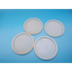 May include: Four white plastic lids with a circular design and a raised rim are arranged on a blue background. The lids appear to be for containers, possibly for food storage or other household uses.