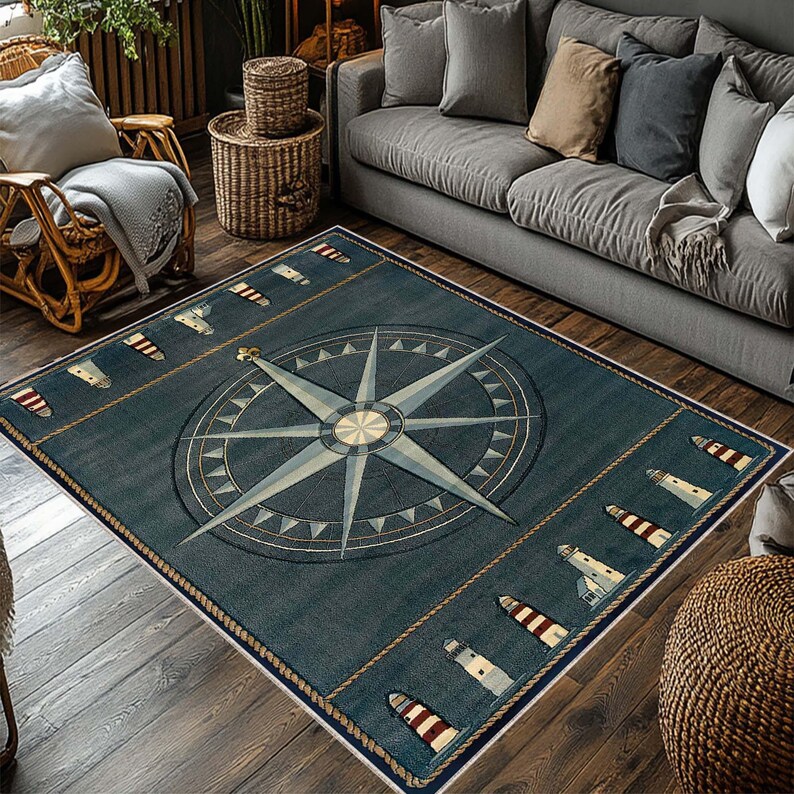 May include: A rectangular navy blue nautical-themed rug featuring a large compass rose design in the center. The rug has a border with rope detailing and images of lighthouses and sailboats. The rug is placed on a wooden floor.