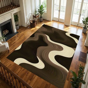 May include: A large area rug with a flowing, layered design in shades of brown and cream. The rug features a wavy pattern created by thin, parallel lines, creating a sense of depth and movement. This floor covering is suitable for a living room or bedroom.