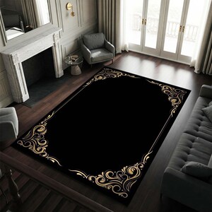 May include: Black area rug with a gold ornate border design. The rug has a classic, elegant style.