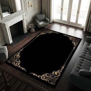 May include: Black area rug with a gold ornate border design. The rug has a classic, elegant style.