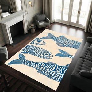 May include: A rectangular area rug with a cream background and a repeating pattern of blue fish illustrations. The fish vary in size and orientation, creating a whimsical design. The rug is placed on a dark wood floor.