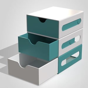 Puede incluir: Unidad de almacenamiento de tres niveles con cajones blancos y turquesa. Los cajones tienen un recorte curvo para facilitar la apertura y un asa rectangular. La unidad está apilada, con un cajón parcialmente abierto.