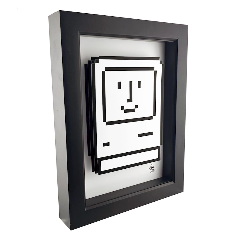 May include: A black framed print of a pixelated computer with a smiling face. The print is in a black frame and has a white background.