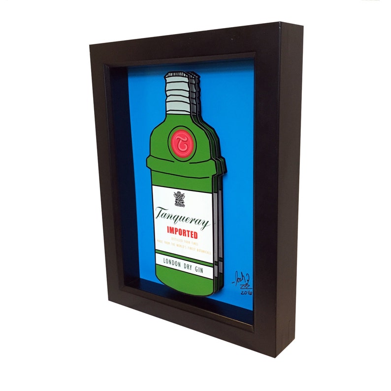 Puede incluir: Una ilustraci&oacute;n enmarcada de una botella de ginebra Tanqueray con fondo azul. La botella es verde y tiene una etiqueta roja con el texto "Tanqueray Imported London Dry Gin".