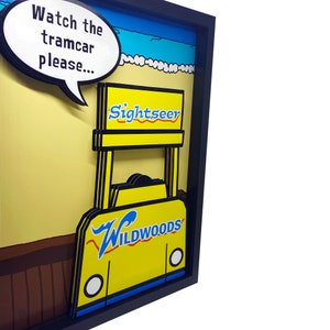 Peut inclure: Un tramway jaune et bleu de style vintage avec les mots "Sightseer" et "Wildwoods" dessus. Le tramway est dans un cadre avec une bulle de dialogue qui dit "Regardez le tramway s'il vous pla&icirc;t..."