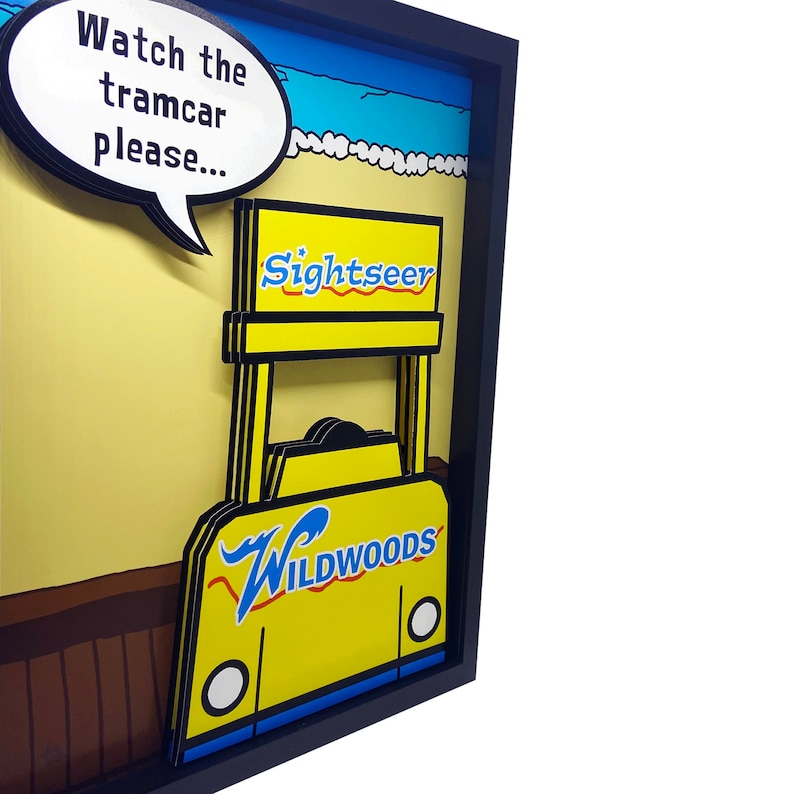 Peut inclure: Un tramway jaune et bleu de style vintage avec les mots "Sightseer" et "Wildwoods" dessus. Le tramway est dans un cadre avec une bulle de dialogue qui dit "Regardez le tramway s'il vous pla&icirc;t..."