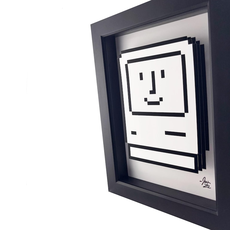 May include: A black framed print of a pixelated computer with a smiling face. The print is signed "Josh 22".