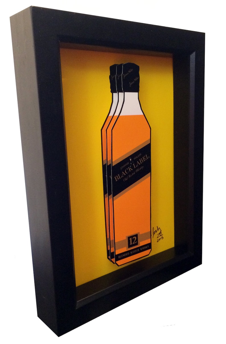 K&ouml;nnte beinhalten: Ein gerahmtes Kunstwerk mit einer 3D-Illustration einer Flasche Johnnie Walker Black Label 12 Jahre alter Blended Scotch Whisky. Die Flasche ist orange und schwarz mit dem Text "Johnnie Walker Black Label" und "12" darauf gedruckt. Das Kunstwerk ist vor einem gelben Hintergrund platziert und mit "Josh 2015" signiert.