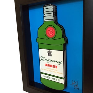 Puede incluir: Una ilustraci&oacute;n enmarcada de una botella de ginebra Tanqueray verde con un c&iacute;rculo rojo y la letra "T" en la parte delantera. La etiqueta de la botella dice "Tanqueray Importado, Destilado Cuatro Veces, Hecho con los mejores bot&aacute;nicos del mundo, Ginebra Seca de Londres". La imagen est&aacute; firmada "Joch? 2016" en tinta negra.