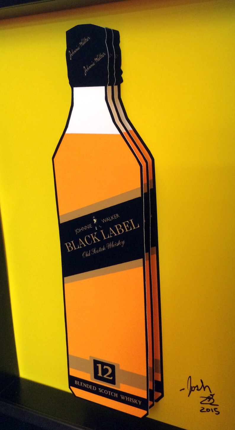 K&ouml;nnte beinhalten: Eine Flasche Johnnie Walker Black Label 12 Jahre alter,  verschnittener Scotch Whisky mit gelbem Hintergrund und Signatur.