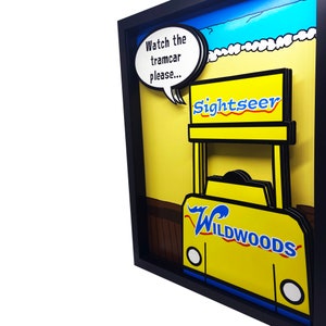 Peut inclure: Une illustration 3D de style pop art jaune et bleue d'un tramway avec les mots "Watch the tramcar please..." dans une bulle de dialogue au-dessus. Le tramway porte les mots "Sightseer" et "Wildwoods".