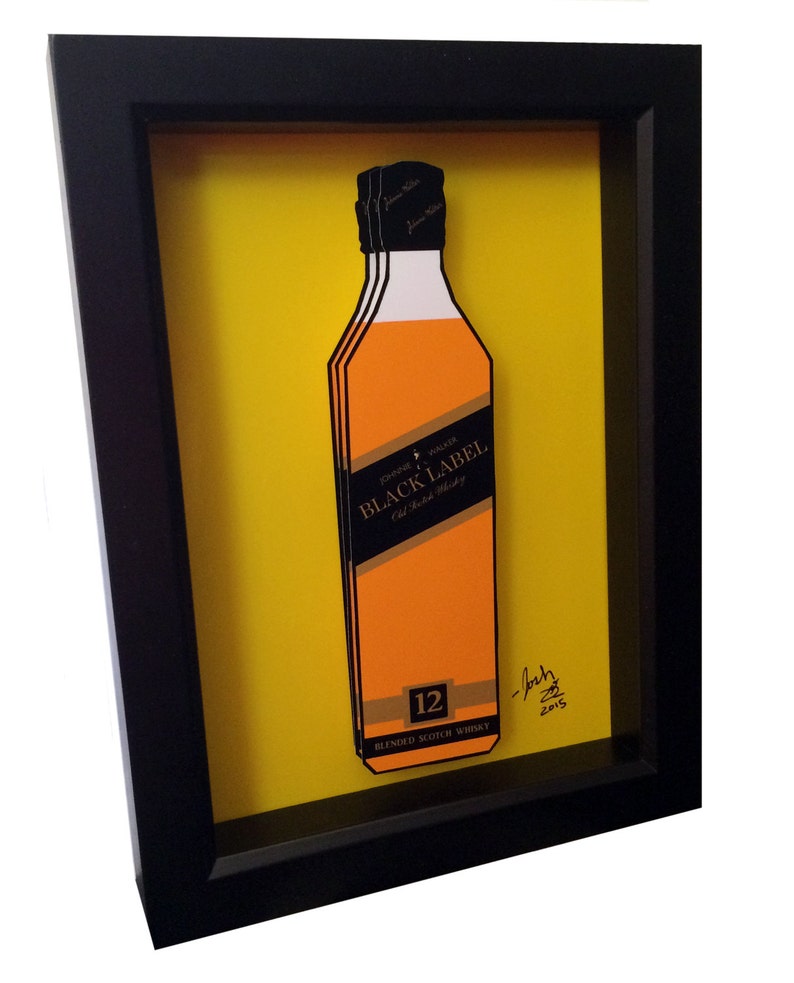 K&ouml;nnte beinhalten: Eine gerahmte Illustration einer Flasche Johnnie Walker Black Label 12 Jahre alter Blended Scotch Whisky. Die Flasche ist in 3D dargestellt, mit gelbem Hintergrund und schwarzem Rahmen. Das Bild ist signiert mit "Josh 2015".