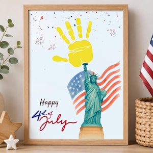 Puede incluir: Una lámina enmarcada con una huella de mano amarilla sobre una ilustración de la Estatua de la Libertad, una bandera estadounidense en acuarela y confeti rojo y azul. El texto Happy 4th of July aparece en letra negra y roja sobre fondo blanco.
