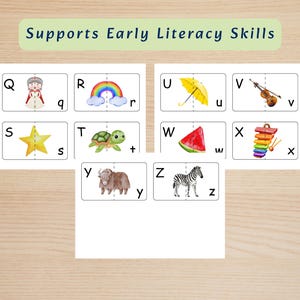 May include: A set of educational flashcards featuring the letters Q through Z with corresponding watercolor illustrations including a queen, rainbow, umbrella, violin, star, turtle, watermelon, xylophone, yak, and zebra, labeled Supports Early Literacy Skills.