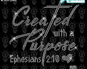 May include: Black digital rhinestone design with the words "Created with a Purpose" and "Ephesians 2:10". The design includes a cross and starburst accents. The size is 26.86 cm wide and 27.87 cm high.