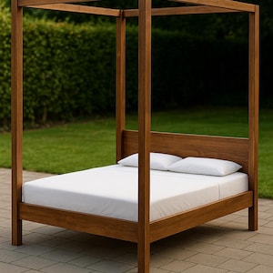 以下が含まれることがあります： 木製のフレームの四柱式ベッド。ベッドにはヘッドボードとフットボードがあり、マットレスは白いシーツと枕で覆われています。ベッドフレームは濃い茶色の木材で作られています。ベッドは石畳のパティオに置かれています。