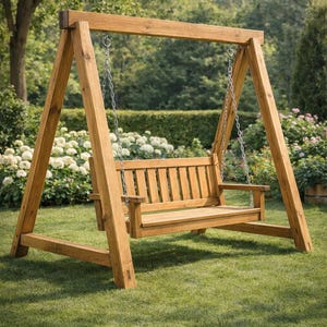 Op de afbeelding: Een houten schommel met een natuurlijke afwerking, opgehangen aan kettingen van een stevige A-frame constructie. De schommel heeft een lattenrugleuning en armleuningen, geplaatst op een groen gazon met een achtergrond van bomen en bloemen.