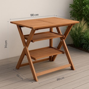 May include: A wooden folding table with two shelves. The table is 35 inches long, 24 inches wide, and 29 inches tall. The table is made of light brown wood and has a slatted tabletop and shelves. The legs are crossed for stability.