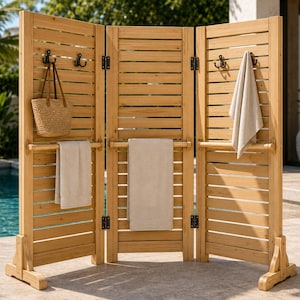 May include: A three-panel wooden privacy screen with horizontal slats, featuring black metal hooks on the upper sections and a horizontal bar across the middle of each panel. The screen holds a woven straw bag and three light-colored towels.