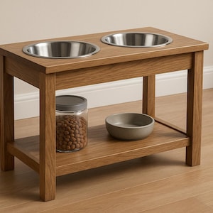Könnte beinhalten: Eine hölzerne Futterstation für Haustiere mit zwei Edelstahlschalen. Ein unteres Regal enthält eine kleine graue Schüssel und ein Glas mit Tierfutter. Der Holztisch hat eine hellbraune Farbe.