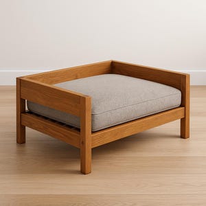 Könnte beinhalten: Ein Haustierbett aus Holz mit hellbraunem Rahmen und einem rechteckigen, grauen Kissen. Das Bett hat ein schlichtes, modernes Design mit Lattenrost und vier stabilen Beinen. Das Kissen wirkt weich und bequem.