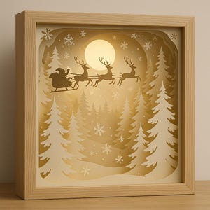 May include: A layered paper art piece in a wooden frame depicts Santa Claus in a sleigh pulled by reindeer, flying across a moonlit winter scene. The artwork features white fir trees and snowflakes, creating a festive holiday display.