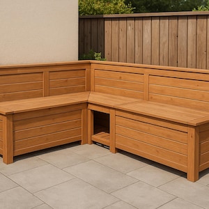 Könnte beinhalten: Eckbank aus Holz mit natürlichem Finish. Die Bank hat eine Rückenlehne und Staufächer. Sie steht auf einer Terrasse mit einem Holzzaun im Hintergrund. Die Bank besteht aus horizontalen Holzbrettern.