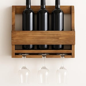 May include: A wooden wine rack with three dark bottles and three wine glasses. The rack is made of stained wood and has a simple, rustic design. The bottles are black and the glasses are clear.