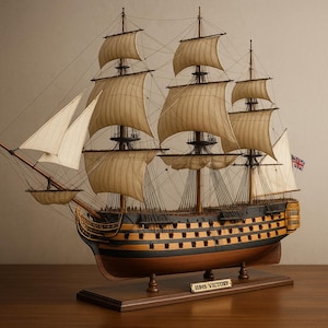 Könnte beinhalten: Ein detailliertes Holzmodell der HMS Victory, einem historischen Segelschiff. Das Modell verfügt über beige Segel, kompliziertes Takelwerk und eine Union Jack-Flagge. Das Schiff wird auf einem Holzsockel mit einem Namensschild ausgestellt.