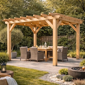 May include: A wooden pergola with a dining table and chairs set up underneath. The pergola has string lights and is surrounded by greenery, including grass, trees, and bushes. The patio is made of stone.