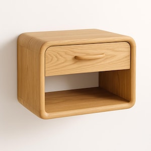 May include: A light oak floating nightstand with a single drawer and open shelf. The nightstand has rounded corners and a curved handle on the drawer. The wood grain is visible throughout the piece, adding to its natural aesthetic.